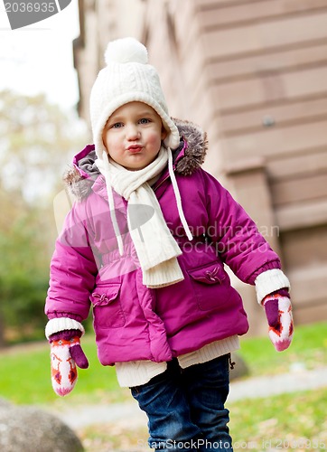 Image of cute little child in pink jacket and hat outdoor