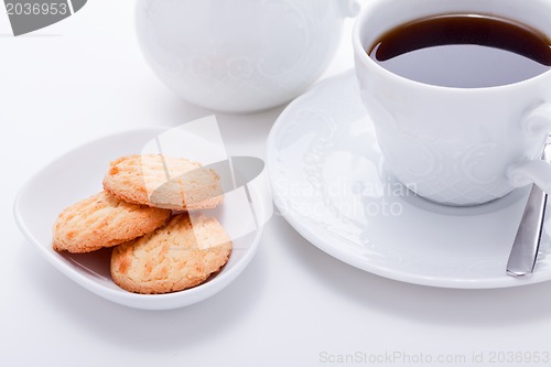 Image of dark coffee in cup homemade cookie on table