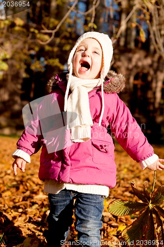 Image of cute little child playing outdoor in autumn