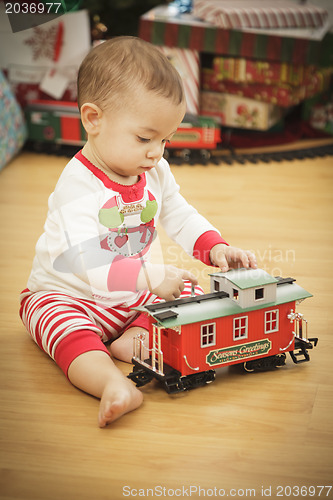 Image of Infant Baby Enjoying Christmas Morning Near The Tree