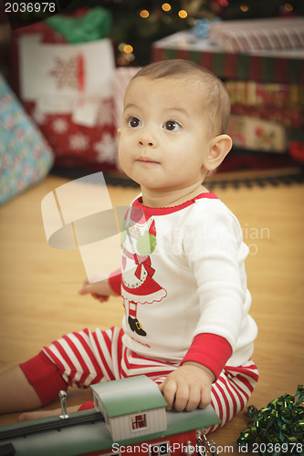 Image of Infant Baby Enjoying Christmas Morning Near The Tree