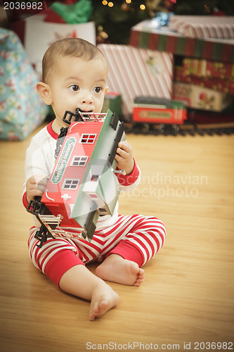 Image of Infant Baby Enjoying Christmas Morning Near The Tree