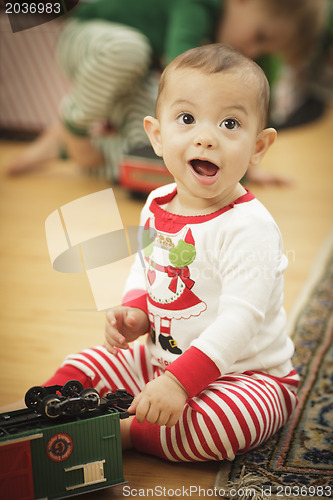 Image of Infant Baby Enjoying Christmas Morning Near The Tree