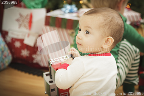 Image of Infant Baby Enjoying Christmas Morning Near The Tree