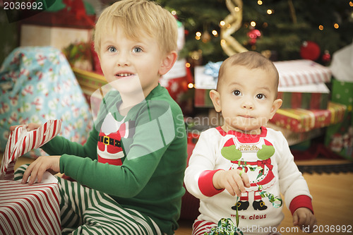 Image of Baby and Young Boy Enjoying Christmas Morning Near The Tree