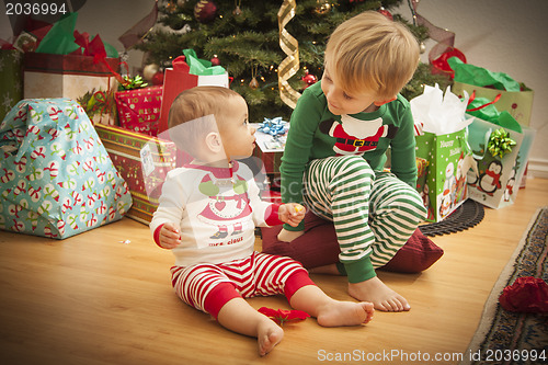 Image of Baby and Young Boy Enjoying Christmas Morning Near The Tree