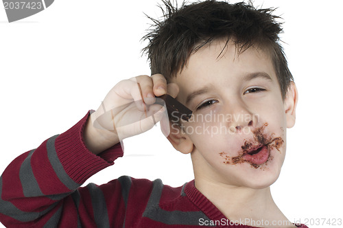 Image of Smiling little boy eating chocolate