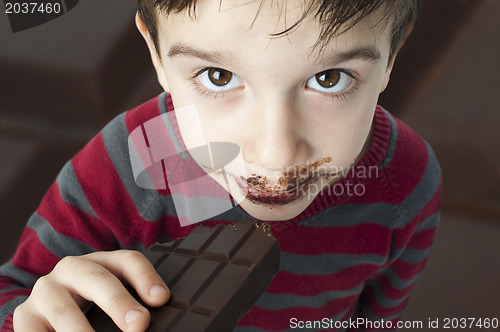 Image of Smiling little boy eating chocolate