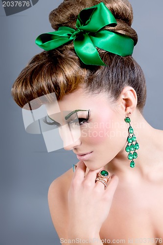 Image of brunette woman with green jewelery and accssesoires