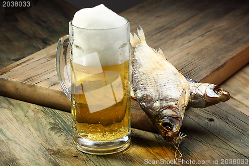 Image of Glass with beer and dried fish. 