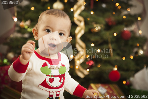 Image of Infant Mixed Race Baby Enjoying Christmas Morning Near The Tree