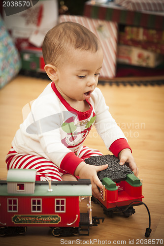 Image of Infant Mixed Race Baby Enjoying Christmas Morning Near The Tree