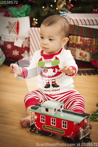 Image of Infant Mixed Race Baby Enjoying Christmas Morning Near The Tree