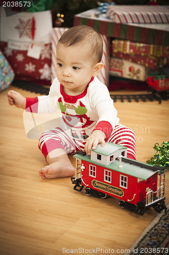 Image of Infant Mixed Race Baby Enjoying Christmas Morning Near The Tree