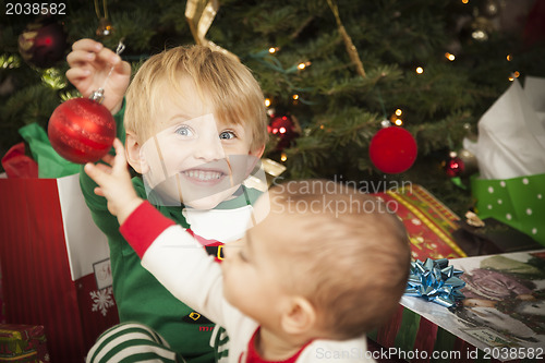 Image of Mixed Race Baby and Young Boy Enjoying Christmas Morning Near Th