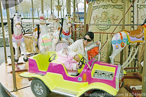 Image of Woman with little child on carousel