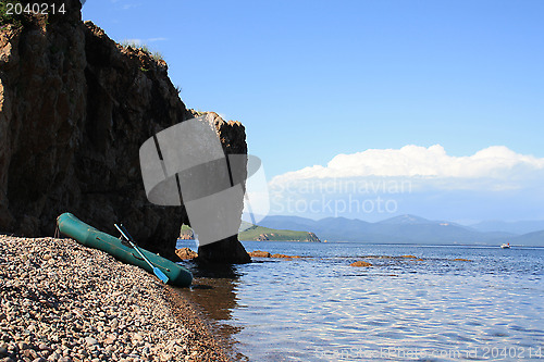 Image of Fishing inflatable boat ashore at a rock