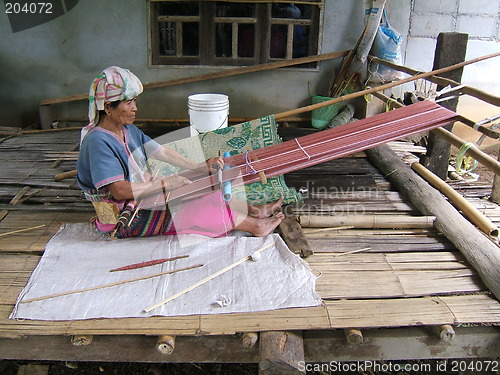 Image of Woman working on a traditional handloom waeving