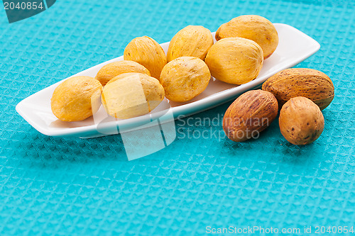 Image of Nuts on a white saucer and near it