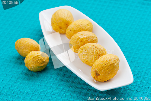 Image of nuts lying in a row on a white saucer