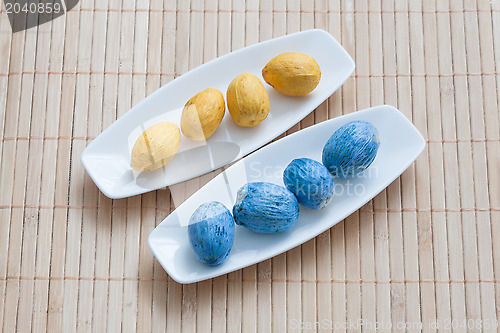 Image of painted yellow and blue nuts on plates
