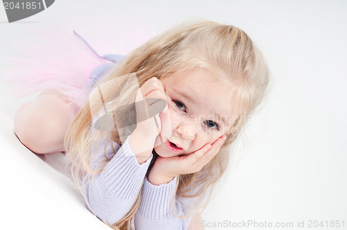 Image of Cute blond girl sitting on the floor