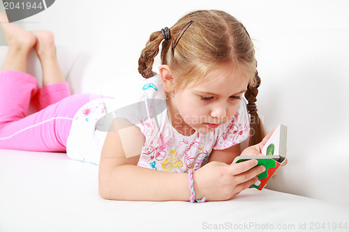 Image of Small girl relaxing and reading