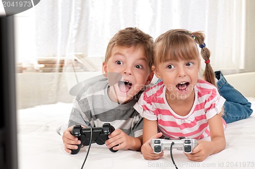 Image of Happy girl and boy playing a video game