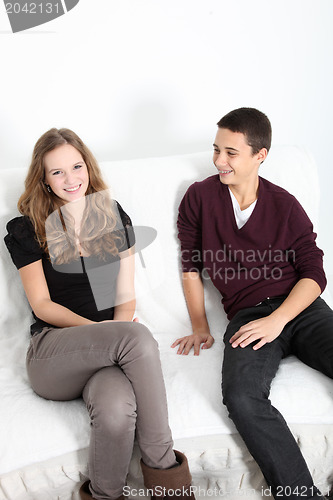 Image of Teenage brother and sister relaxing at home