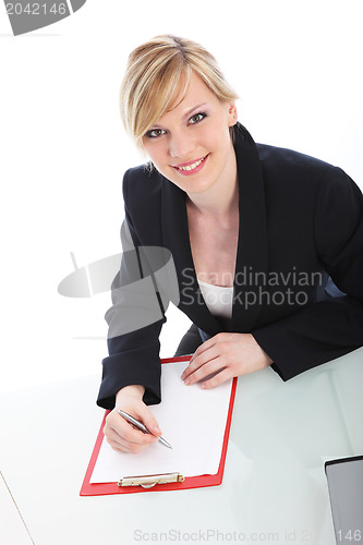 Image of Businesswoman writing on a clipboard