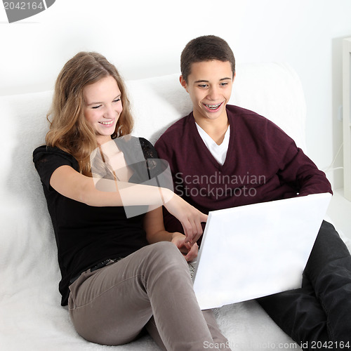Image of Teenage couple laughing at their laptop