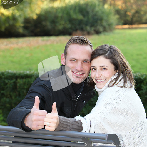 Image of Happy young couple giving a thumbs up