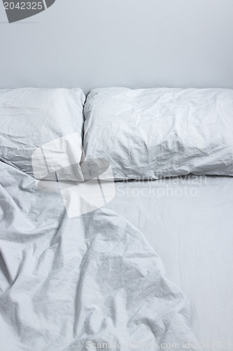 Image of Messy bed with gray bedclothes