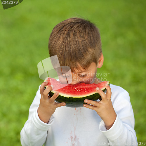 Image of Little boy eating a fresh watermelon