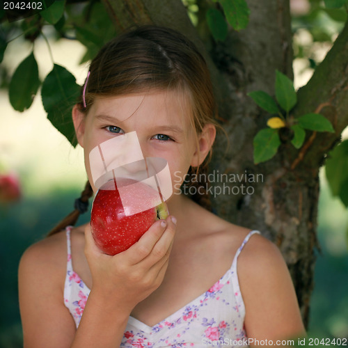 Image of Little girl biting into an apple