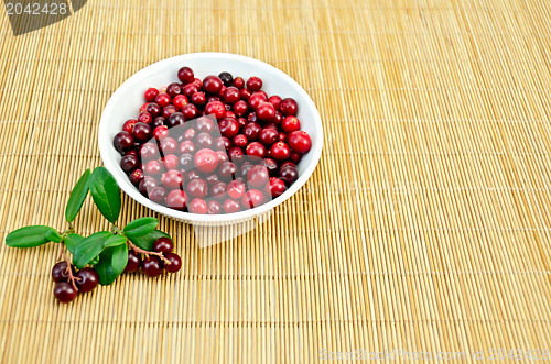 Image of Lingonberry in a cup on a bamboo mat