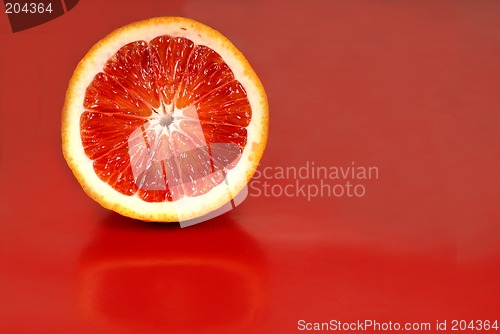 Image of Half of a blood orange on a red background