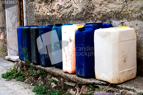 Image of Row of colorful Jerry Cans on the street - Italy