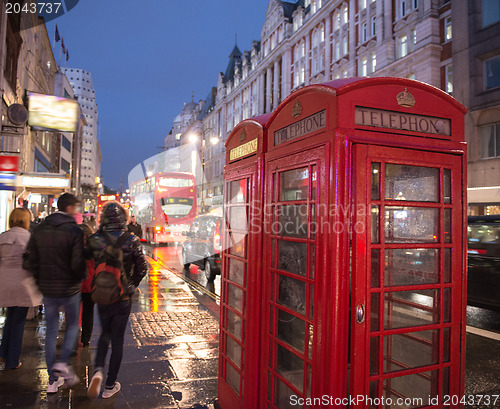 Image of Red Telephone Booth in London on a crowded street at night