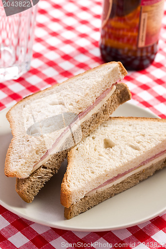 Image of ham sandwich on checkered tablecloth