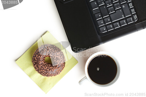 Image of break in the  office . doughnut on laptop keyboard