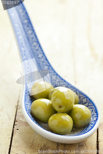 Image of the green olives in ceramic spoon