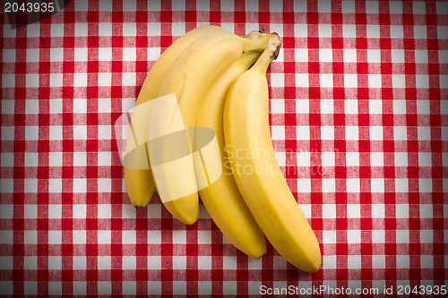Image of yellow bananas on checkered tablecloth
