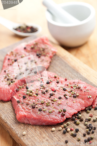 Image of raw beef steak with pepper
