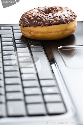 Image of break in the  office . doughnut on laptop keyboard