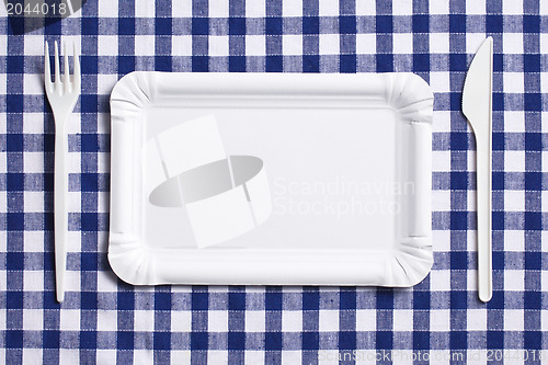 Image of plastic cutlery on checkered tablecloth