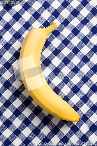 Image of yellow banana on checkered tablecloth