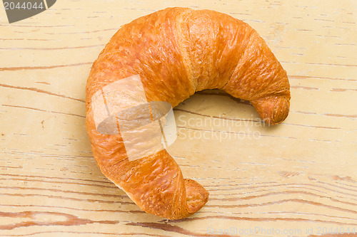 Image of fresh croissant on wooden table