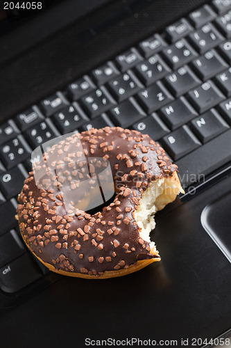 Image of break in the  office . doughnut on laptop keyboard