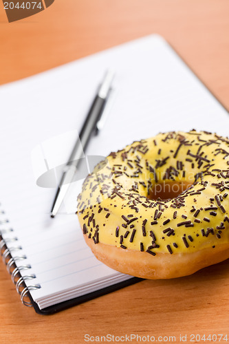 Image of sweet doughnut and spiral notebook